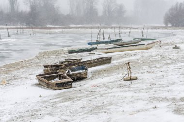 Tuna Nehri 'nin kıyısında donmuş suda demirli ahşap bir balıkçı teknesi..