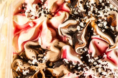 An array of colorful ice cream of different flavors in a plastic box on a hot summer day.