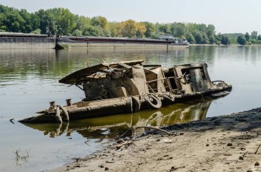 The wreck of an old fishing boat. The wreck of an old fishing boat submerged in the water of the Danube River.