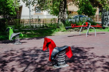 Novi Sad, Sırbistan. Nisan - 26. 2022 yılı. Güneşli bir bahar günü erken saatlerde oynanacak slayt ve oyunlar da dahil olmak üzere çeşitli oyuncakları olan renkli oyun alanı ekipmanları..