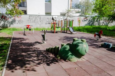 Novi Sad, Sırbistan. Nisan - 26. 2022 yılı. Güneşli bir bahar günü erken saatlerde oynanacak slayt ve oyunlar da dahil olmak üzere çeşitli oyuncakları olan renkli oyun alanı ekipmanları..