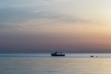 Fishing boat on the high seas, in the early morning hours in Leptokarya,Greece. clipart