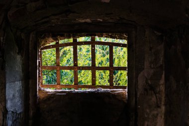 Petrovaradin Kalesi 'nin duvarında metal parmaklıklar olan eski pencere..