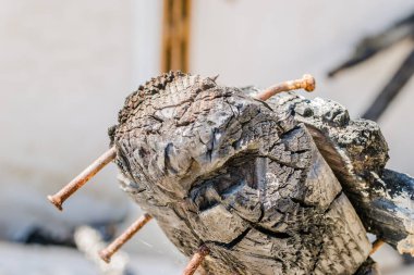 The remains of the burnt house. Ruined and collapsed house burnt and damaged in the fire with remains of the wooden reinforcement poles of roof selective focus. Burned house