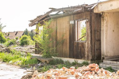 The remains of the burnt house. Ruined and collapsed house burnt and damaged in the fire with remains of the wooden reinforcement poles of roof selective focus. Burned house