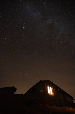 Hohe Tauern dağlarındaki Avusturya Alpleri 'nin dışında bir dağ kulübesinin gece görüntüsü parladı.