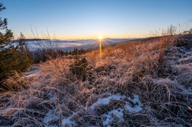 Çek Cumhuriyeti 'nin Beskydy dağlarında güneş doğarken ve sabah donarken tepelerde dağ manzarası