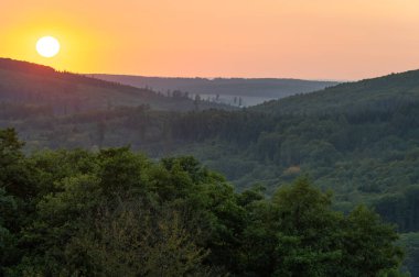 Çek Cumhuriyeti 'nin Chiby dağlarındaki kayın ormanlarıyla tepelerde gün batımı