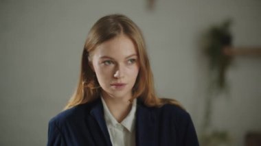 Gorgeous young woman in business casual outfit smiling at camera. Cheerful girl expressing positive emotions and blinking. High quality 4k footage