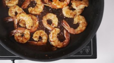 Top view of shrimps frying in oil. Delicious seafood cooking process. Deep fried prawns preparation on the stove. High quality FullHD footage