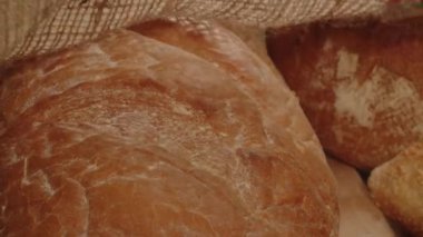 Fresh long loaf at the bakeshop. Fresh bakery products demonstration. Close-up slow motion view of bread slicing process. High quality 4k footage