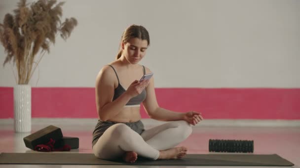 Sporty Girl Sitting Yoga Mat Crossed Legs Texting Someone Beautiful — 图库视频影像