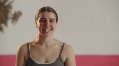 Front view of happy girl looking aside and pointing with finger. Smiling young woman showing thumbs up. Happy female model making approval gesture. High quality 4k footage