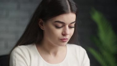 Kafkasyalı kız ciddi bir bakışla meşgul. Gözleri yere bakan serbest çalışan bir kız. Yüksek kalite 4k görüntü