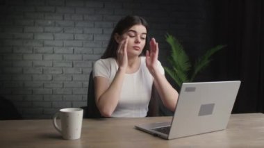Tired woman having headache from her job. Girl freelancer massaging her forehead trying to figure out how to solve the problem. Problems with remote work. High quality 4k footage