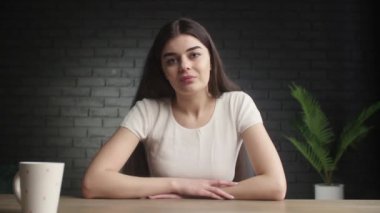Kadın blogcuların takipçilerini selamlaması ön planda. Beyaz kız kameraya elini sallıyor ve gülümsüyor. Uzaktan kumandalı bir iş için online görüşme yapan genç kadın. Yüksek kalite 4k görüntü