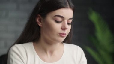 Tired young woman having headache. Video of attractive girl rubbing her forehead trying to figure out how to solve a problem. Difficult choice. High quality 4k footage