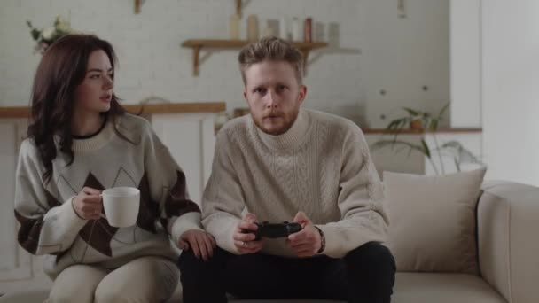 Young Brunette Brings Cup Coffee Her Boyfriend Playing Console Video — Vídeo de Stock