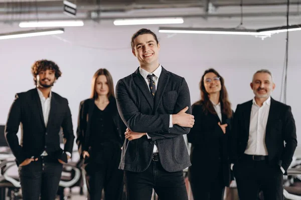 Startup founder posing with his business team. Group of smiling businesspeople looking at camera. Front view of ambitious office workers. High quality photo