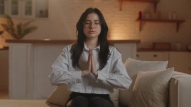 A brunette girl in glasses folds her hands in prayer, begging for something, making a wish. A woman prays for a successful job interview. High quality 4k footage