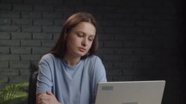 Uykulu kadın dizüstü bilgisayarın önünde otururken esniyor. Bir esmer, online bir konferansı dinlerken esneme nöbeti geçirir. Yüksek kalite 4k görüntü