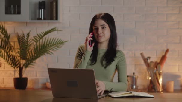 ビジネスマンは彼女の従業員と電話で仕事の計画を議論する ブルネットの女性は自宅のオフィスでビジネス会話をしています スマートフォンやノートパソコンを持つ女性のフリーランサー 高品質4K映像 — ストック動画