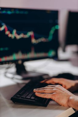 Cropped view of stockbroker with financial chart on the screen. Partial view of office worker analyzing data. Programmer coding in office. Trader working with computer. High quality photo