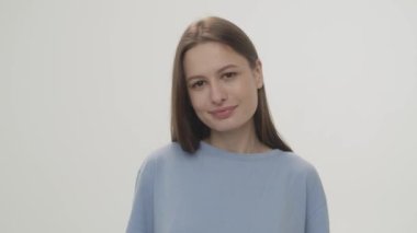 Beautiful woman looking at the camera with a slight smile on her lips. Close-up shot of a young smiling brunette. High quality 4k footage
