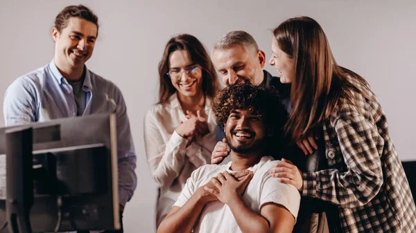 Friendly atmosphere in office. Happy coworkers celebrating successful ideas. Startup teamwork. Group of managers laughing during work process. High quality photo
