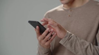 Cropped view of man using smartphone.Man taps and scrolls with finger on smartphone screen. High quality 4k footage