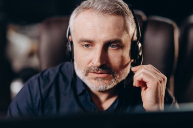 Focused call center operator listens carefully to the customer. Portrait of concentrated telesales marketer in headset talking to client. High quality photo