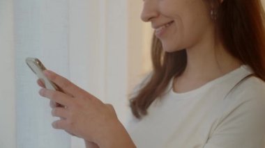 Esmer bir kadının akıllı telefonuna bir şey yazdığını gördüm. Gülümseyen kadın bir kuryede arkadaşlarıyla sohbet ediyor. Yüksek kalite 4k görüntü