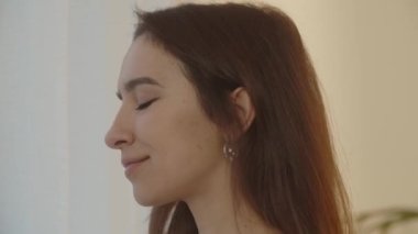 Güzel bir kadın elinde bir fincan sıcak çayla pencereye gelir. Pencerenin manzarasına hayran olan bir kızın yakın çekimi. Yüksek kalite 4k görüntü