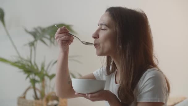 Video Una Joven Comiendo Avena Tazón Blanco Morena Pelo Largo — Vídeos de Stock