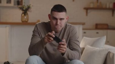 Video oyununa dalmış olan genç adam, seviyeyi tamamlayamadıktan sonra yüksek sesle yemin etti. Kısa saçlı bir adam oyunda zor bir seviyeyi geçemediği için üzgündü. Yüksek kalite