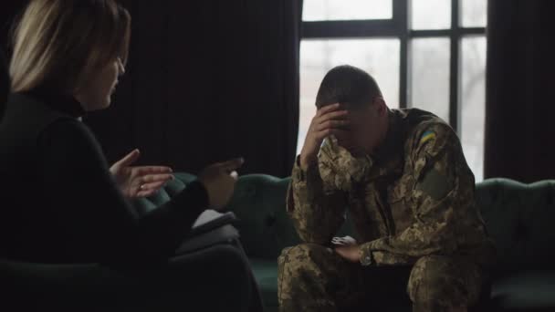 一名年轻的乌克兰士兵因抑郁症而转向心理治疗师 抑郁症是因参与敌对行动而引起的 一个身穿军服的抑郁症患者听着 — 图库视频影像