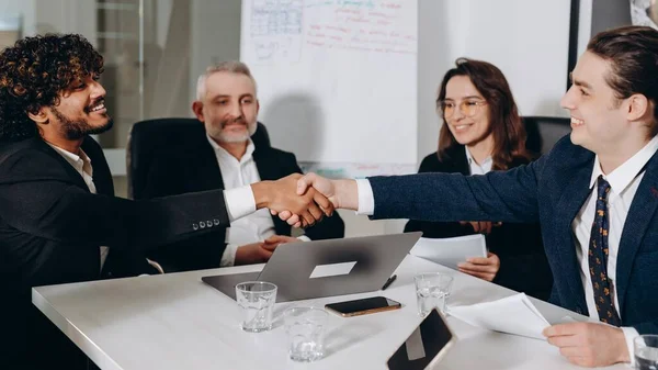 stock image Smiling business partners shaking hands at the conference. Happy businessmen giving a handshake after successful agreement. Business deal. High quality photo