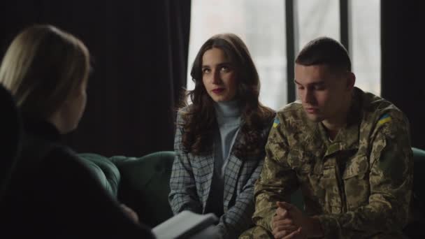 Ptsdを持つウクライナの兵士と彼のガールフレンドは軍事心理学者と治療を持っています 若い女性はリハビリテーション中にサービスマンの夫をサポートします 戦争のベテランの適応 ウクライナの防衛者 — ストック動画