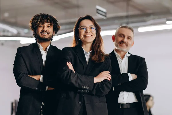 Diverse business team posing with smile. Confident businesspeople standing with arms crossed in office. High quality photo