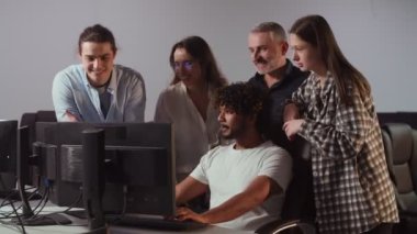 Bilgi işlem çalışanları monitöre bakıp bir şeyi tartışıyor. Bilişim uzmanları işin karmaşıklığını yeni bir çalışana açıklar. Takım çalışması konsepti. Yüksek kalite 4k görüntü