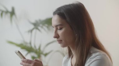 Akıllı telefon kullanan bir kadının yakın plan fotoğrafı. Esmer parşömenler akıllı telefonunun ekranında, kaçırılan ihbarlara bakıyor, haberlere bakıyor. Yüksek kalite 4k görüntü