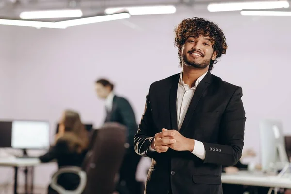 野心的な起業家がカメラで笑っている オフィスでハンサムな若いビジネスマンの屋内ショット 正の感情を表現する経営者男 高品質の写真 — ストック写真