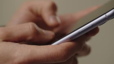 Akıllı telefonunu kullanan bir adamın görüntüsü. Bir adam elinde bir akıllı telefon tutuyor ve bir mesaj yazıyor. Telefon kullanıcısı biriyle konuşuyor. Yüksek kalite 4k görüntü