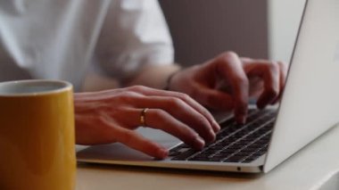 Bir kafeden dizüstü bilgisayarla çalışan bir adamın görüntüsü. Bir adam dizüstü bilgisayarda klavyeye yazı yazıyor ve parmaklarını dokunmatik pedin üzerinde gezdiriyor. Yüksek kalite 4k görüntü