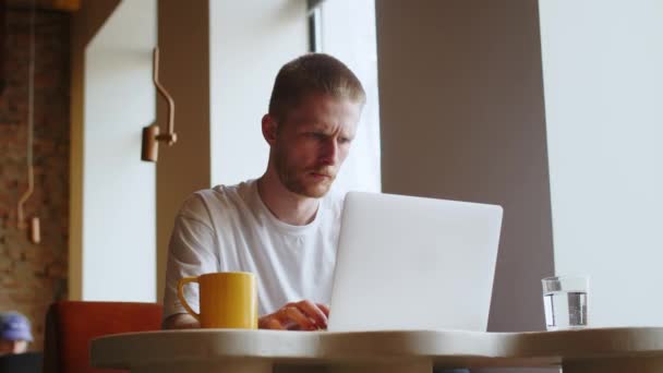 Een Fronsende Man Typt Iets Het Toetsenbord Van Zijn Laptop — Stockvideo
