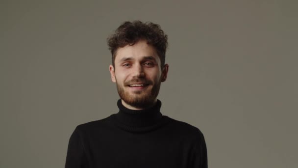 Uomo Sorridente Con Una Felpa Nera Guarda Direttamente Nella Macchina — Video Stock