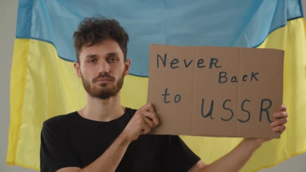 乌克兰男子举着反犹主义标志 挥动着他的手指 年轻人在乌克兰国旗前抗议苏联 乌克兰爱国者做政治行动 别再回苏联了高质量4K — 图库视频影像