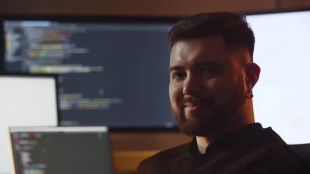 차려입은 남자가 카메라를 웃는다 미소짓는 개발자가 자신의 사무실에 코드를 가지고 — 비디오