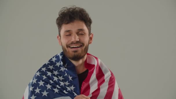 Glimlachende Krullende Man Met Amerikaanse Vlag Die Naar Camera Kijkt — Stockvideo