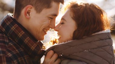 Birbirine aşık bir kadınla erkeğin göz göze geldiği yakın çekim. Gülümseyen kızıl saçlı kadın erkek arkadaşına sarılıyor. Yüksek kalite fotoğraf